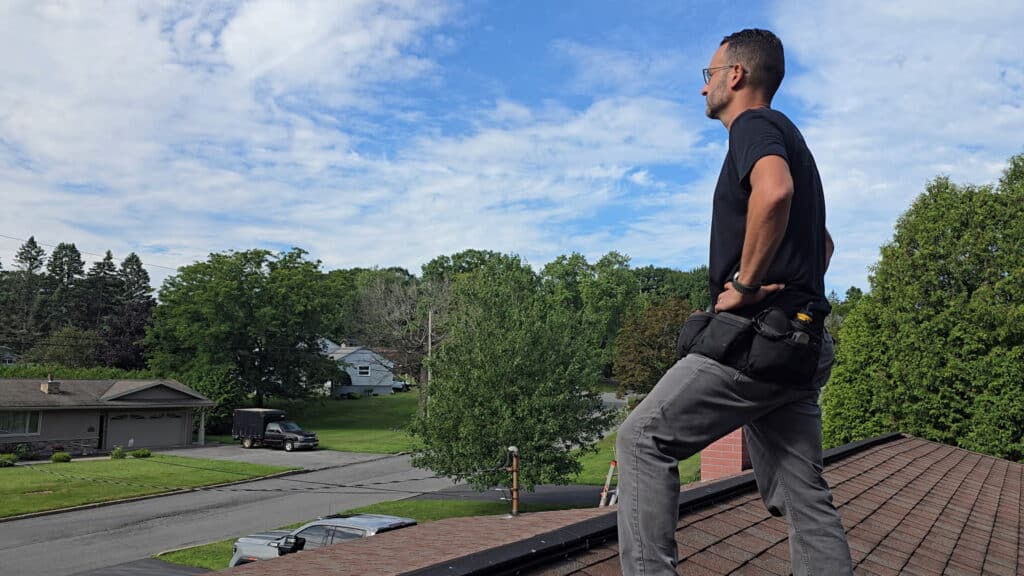 Inspector inspecting roof for property condition assessment.