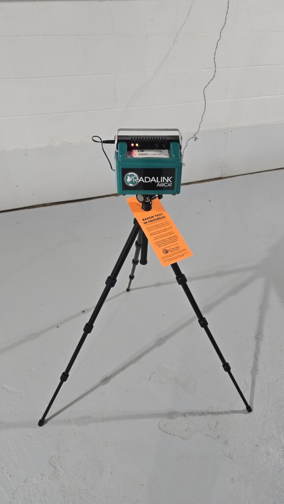 Radon testing monitor on a tripod measuring indoor radon levels