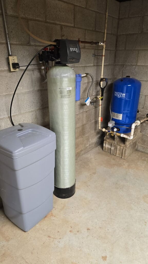Private well water system with pressure tank and water treatment equipment