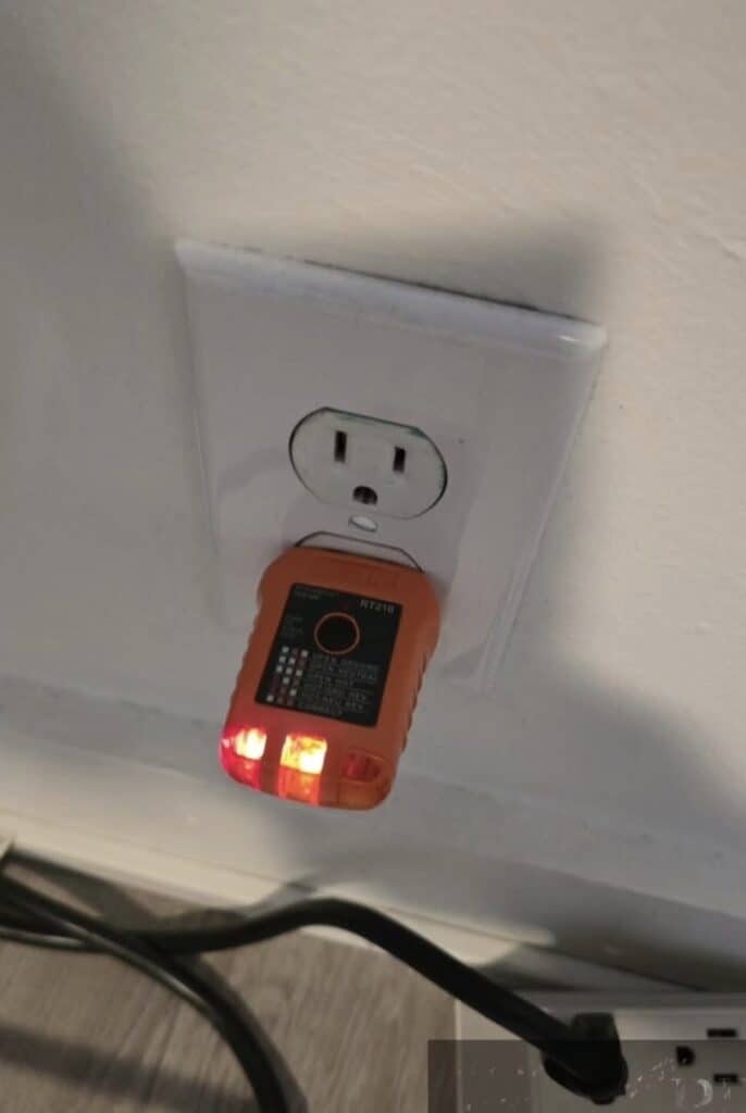 Electrical outlet being tested with a receptacle tester during a home inspection